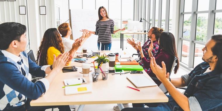 A marketing team applauds at a meeting.