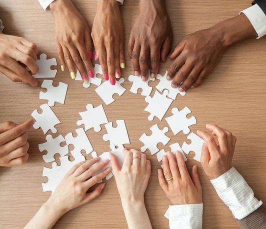 Picture of employees working together on a puzzle.