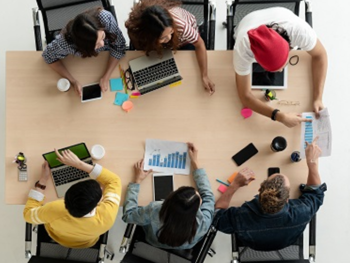 A group of workers around a table looking at documents.