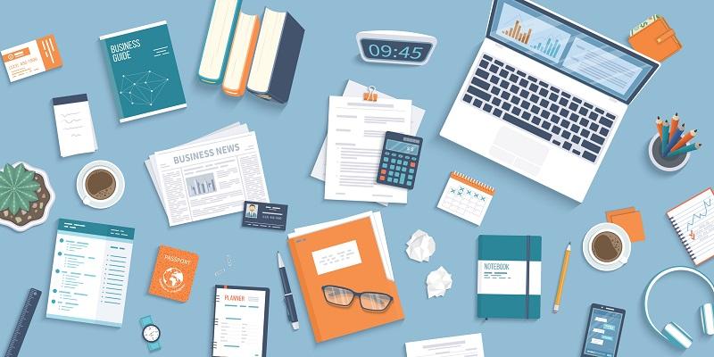 An office desk filled with tools and notebooks.
