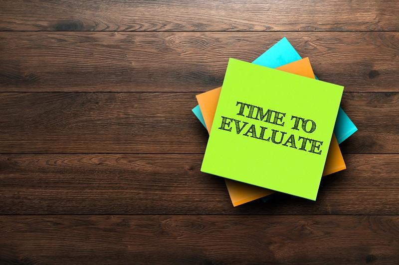 A picture of notes on a desk, the top one reads, "Time to evaluate".