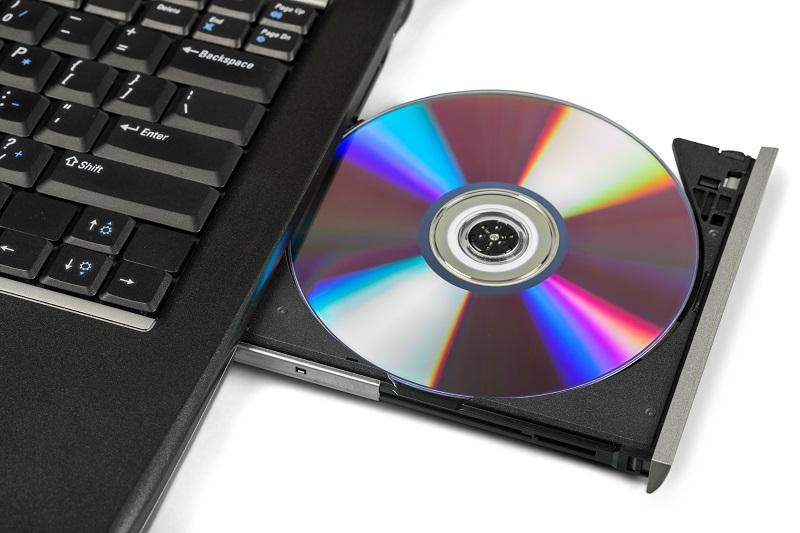 Eine CD-Rom liegt im geöffneten CD-ROM-Laufwerk eines Laptops.