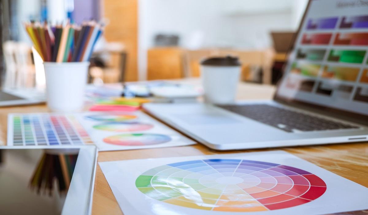 A laptop surrounded by drawings.