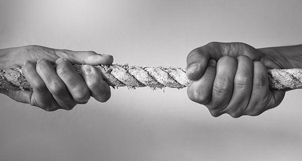 Two people tugging on a rope.