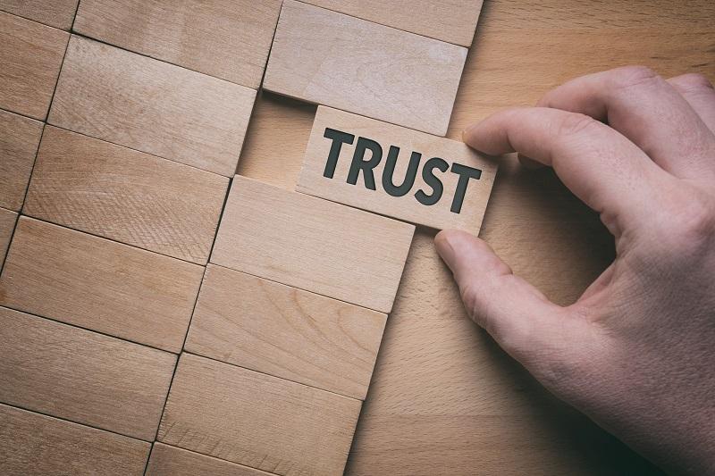 The word 'trust' written on a puzzle block.