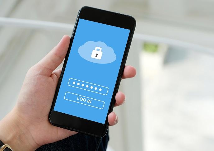 Eine Hand hält ein Smartphone, auf dem eine Wolke mit einem Schloß eine sichere Cloud-Lösung symbolisiert.