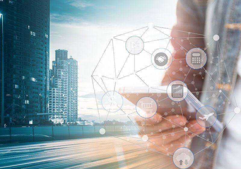 Ein Mann hält ein Mobiltelefon, darum sind Symbole für verschiedene Werkzeuge aus der Datenanalyse angeordnet.