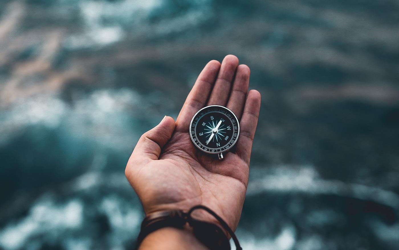 A person holding a compass in their hand.