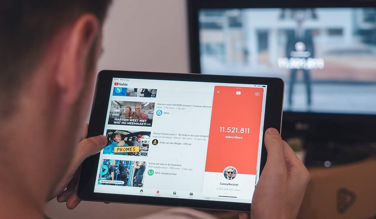 A man watching YouTube on a tablet.