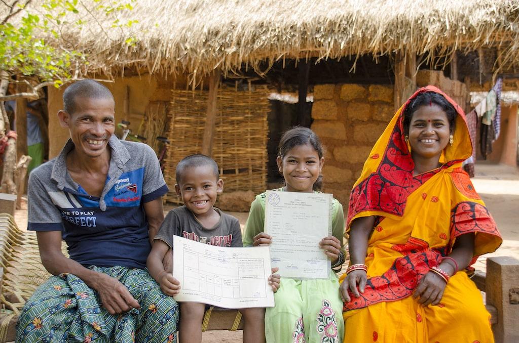 A happy family with two children sitting in a village.