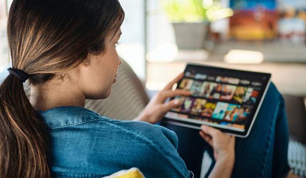 A person renting a movie on a tablet.
