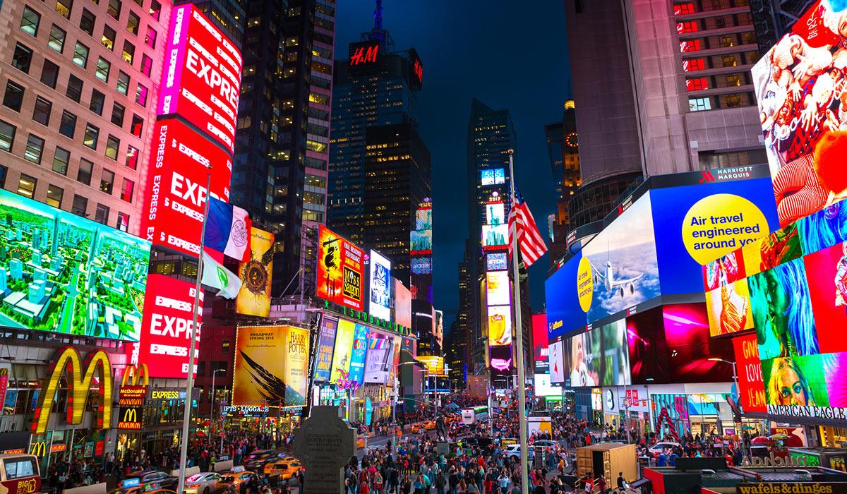 A crowded street with many digital ads.