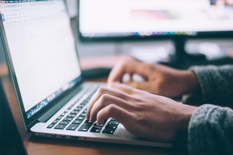 A person types on a laptop.