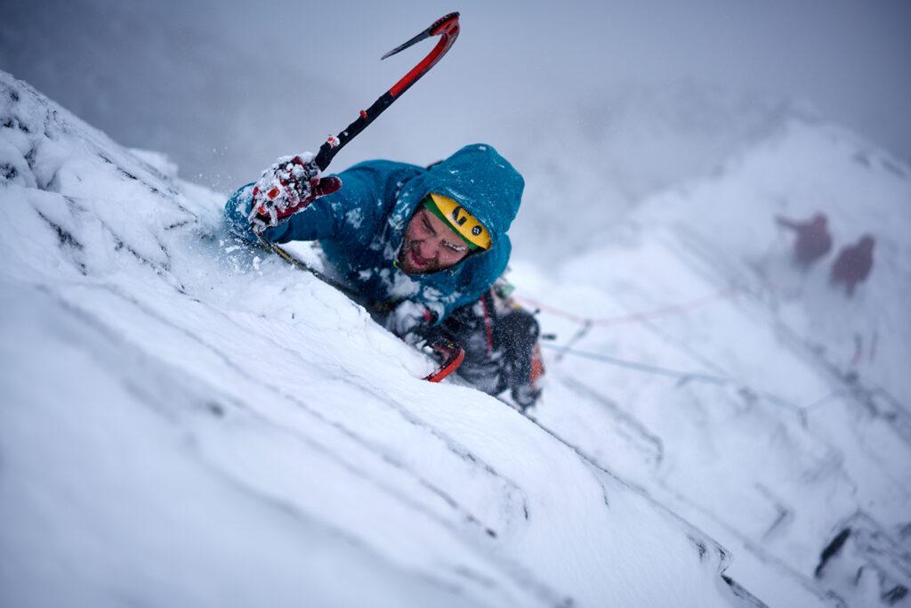 A man climbing a frozen mountainside.