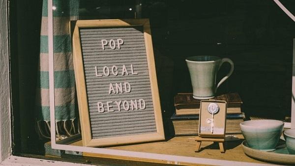 Im Schaufenster eines Ladens steht ein Schild.