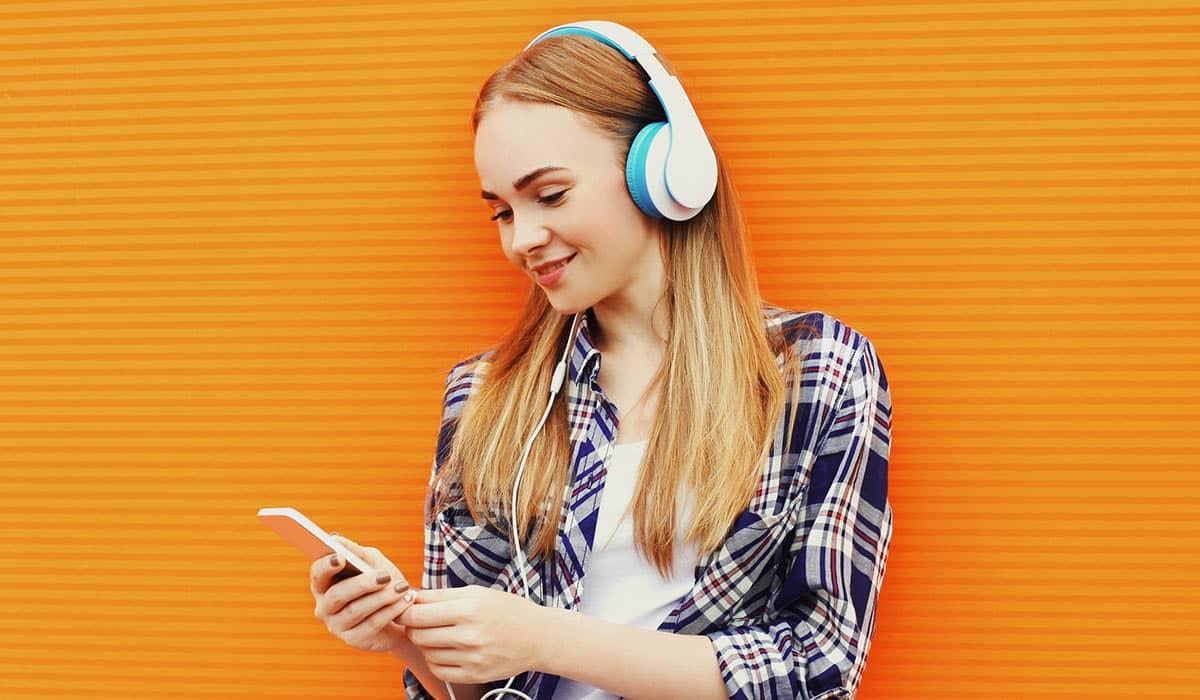 Eine junge Frau hört einen Podcast zum Thema 'die besten Branding-Podcasts'.