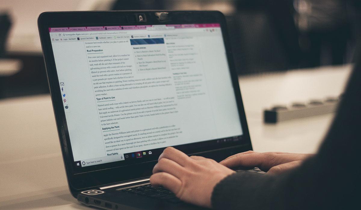 Eine Person schreibt auf einem Laptop einen Blog.