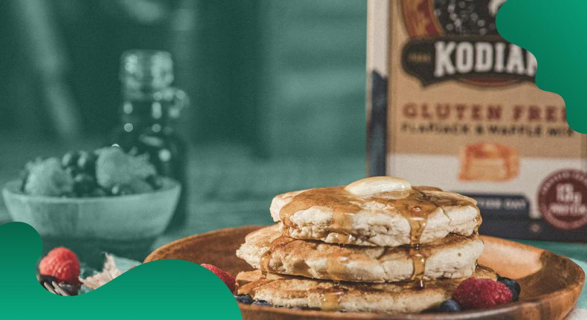 Kodiak Cakes header image in green showing a stack of pancakes with fruits.