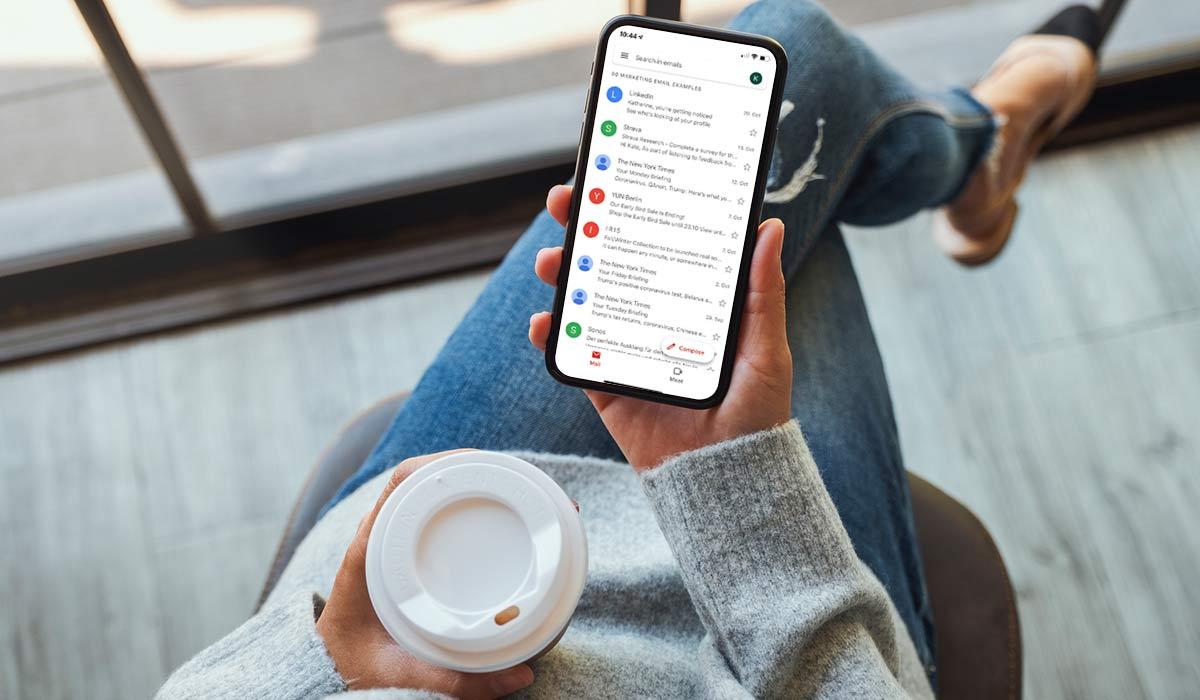 Eine Frau sieht sich den Posteingang ihres E-Mail-Kontos auf ihrem Smartphone an.