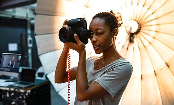 Photographer looks through viewfinder in a photo studio.