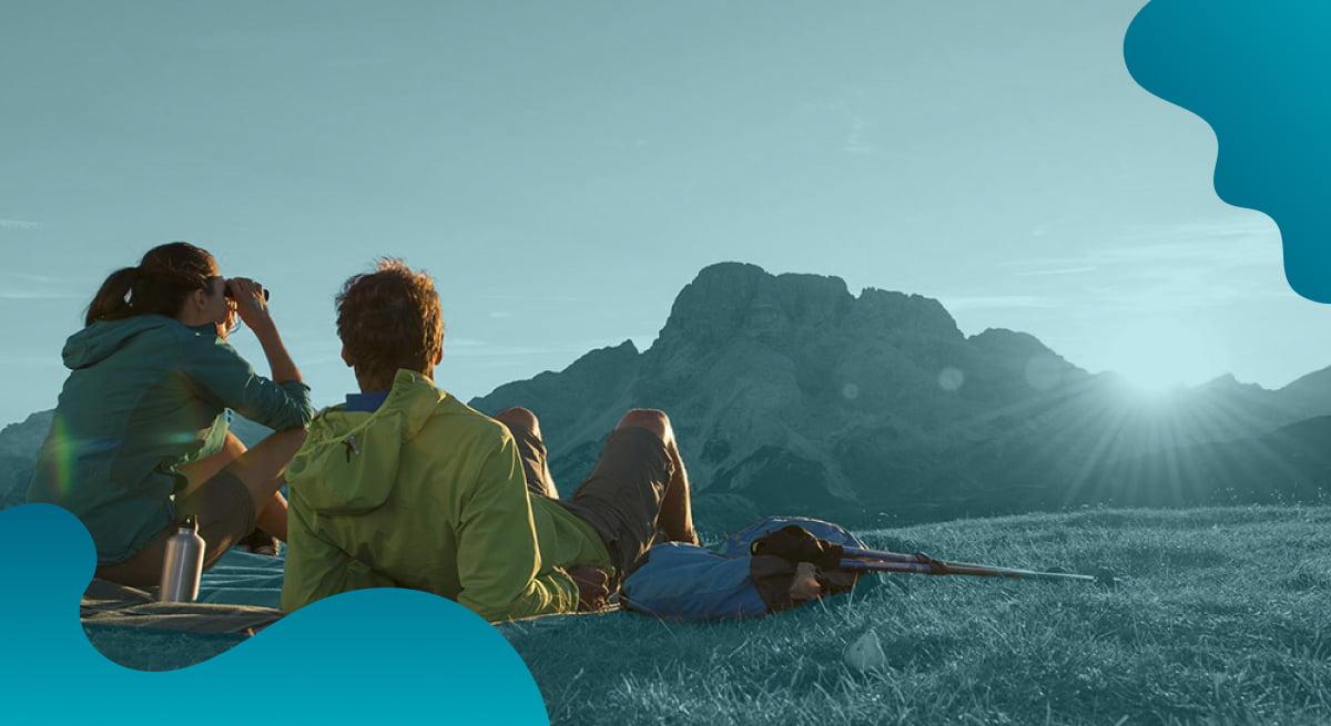Das Titelbild von IDM Südtirol in Blau zeigt ein Paar, das die malerische Aussicht genießt.