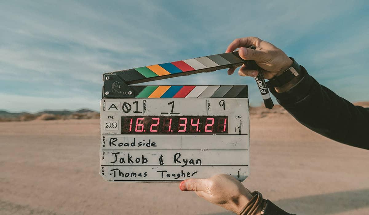 Eine Filmklappe mit Informationen bei einem Außendreh.