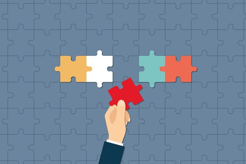 Eine Hand setzt ein Puzzle zusammen.