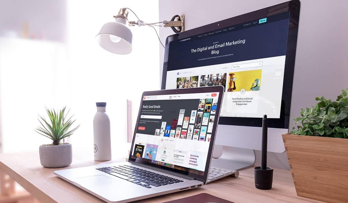 Ein Laptop und ein PC-Bildschirm auf einem modernen Schreibtisch, auf ihnen werden verschiedene E-Mail-Marketing-Ressourcen angezeigt.