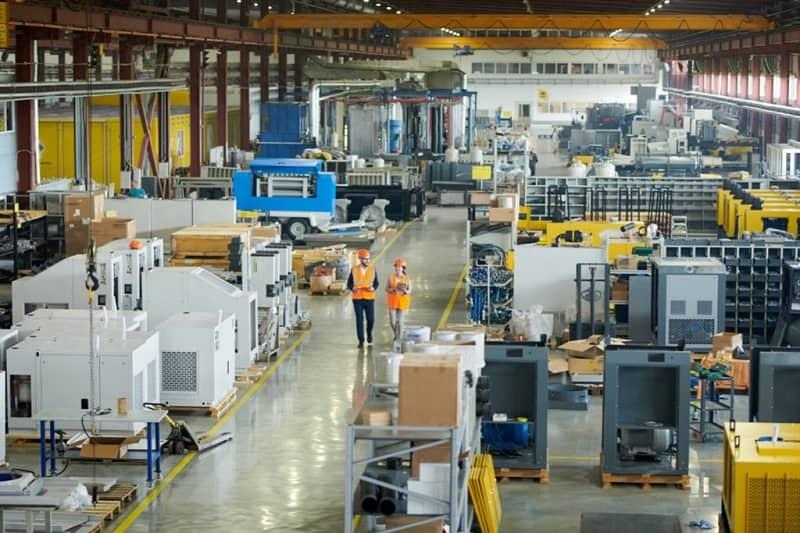 Zwei Techniker auf dem Weg durch eine Fabrikhalle.
