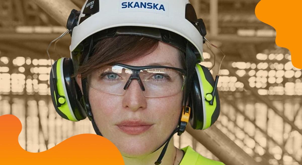 Skanska header image in orange of worker wearing protective equipment on a construction site.