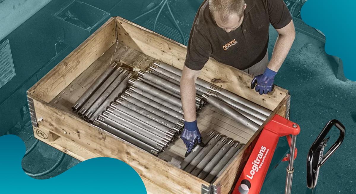 Logitrans header image in blue of worker moving manufacturing parts.