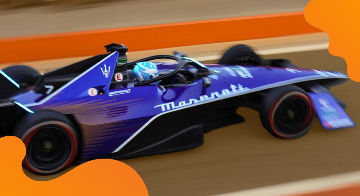 Maserati header image in orange of vehicle racing on a course track.