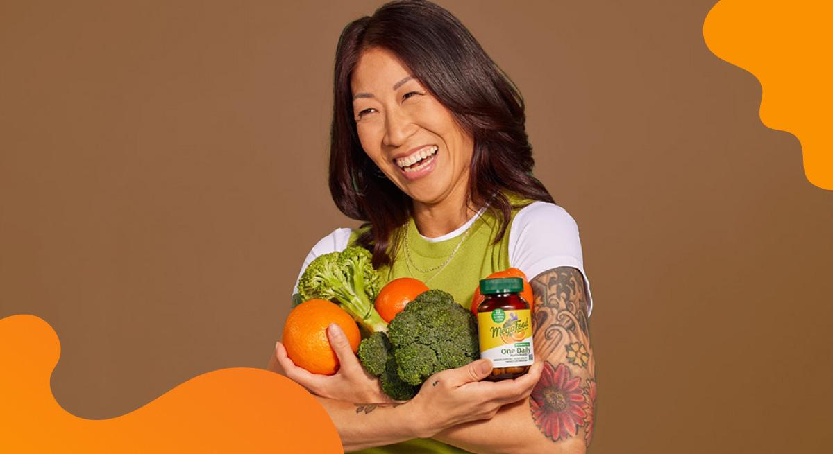 Megafood header image in orange of woman holding vegetables