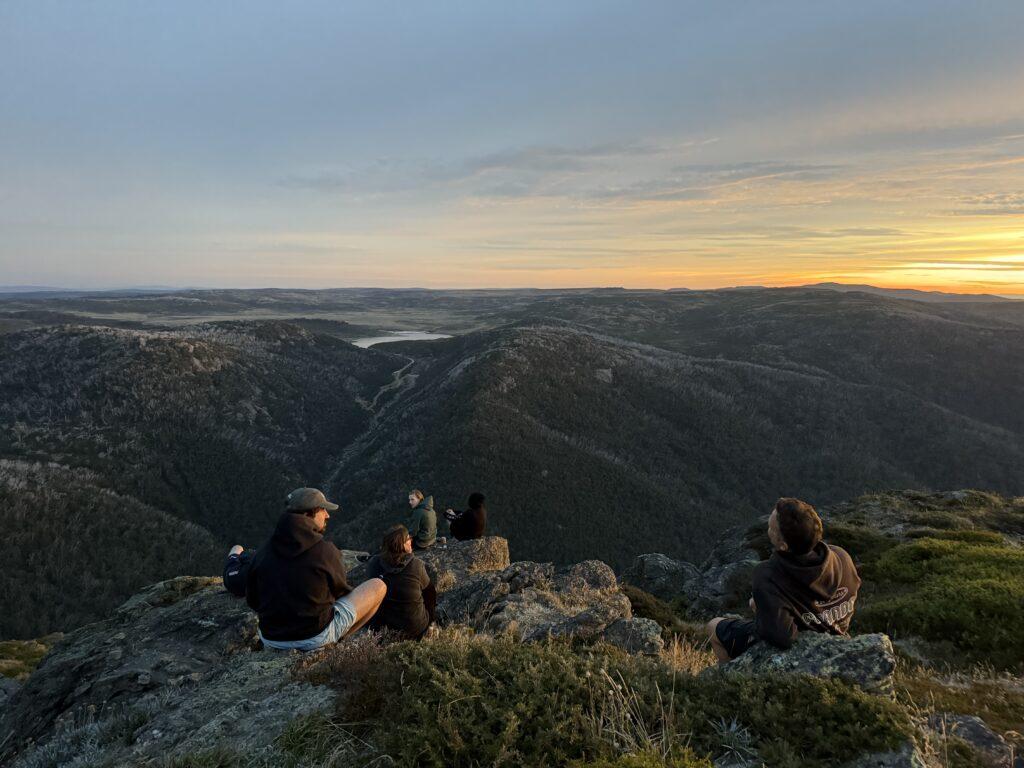 Knog brand photo of team sitting and looking over mountains