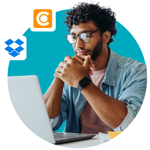 Eine Person vor blauem Hintergrund vergleicht auf einem Laptop Dropbox mit DAM.