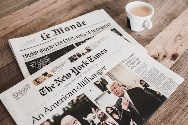 Front pages of New York Times and Le Monde print editions.
